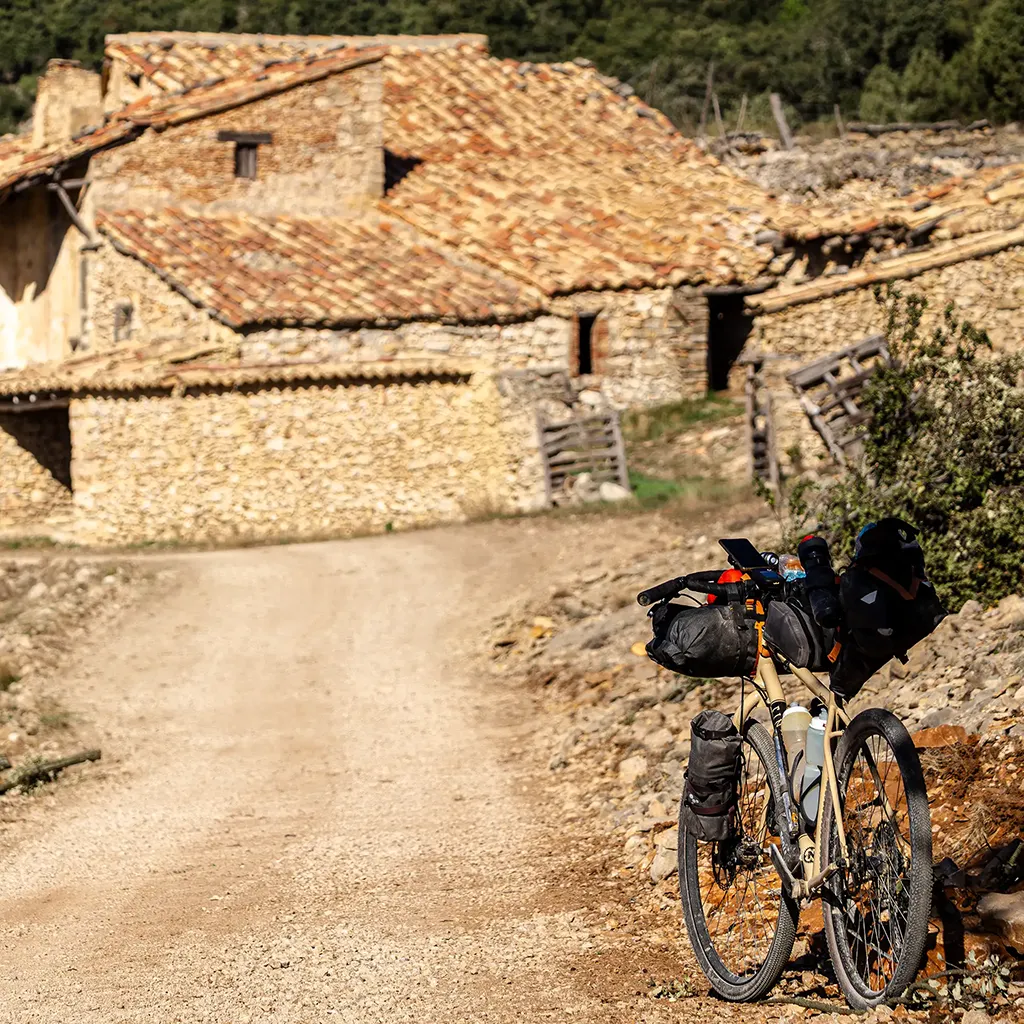 Bicicleta de gravel y masía de fondo