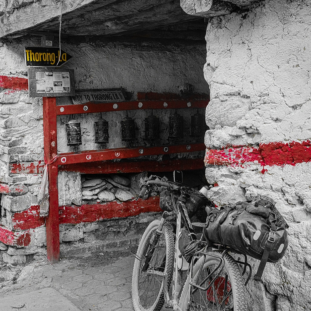 Bicicleta apoyada junto al cartel de Thorong-La